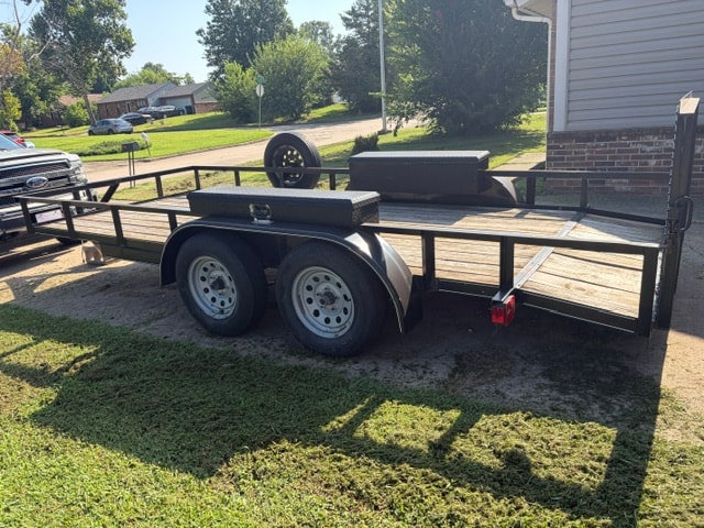 Precision utility trailer — side view showing dual axles and toolbox